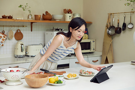 女性在厨房操作平板电脑图片
