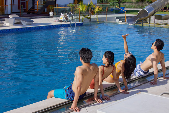 度假酒店泳池边晒太阳的青年们图片