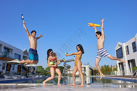在泳池欢乐蹦起的青年男女图片
