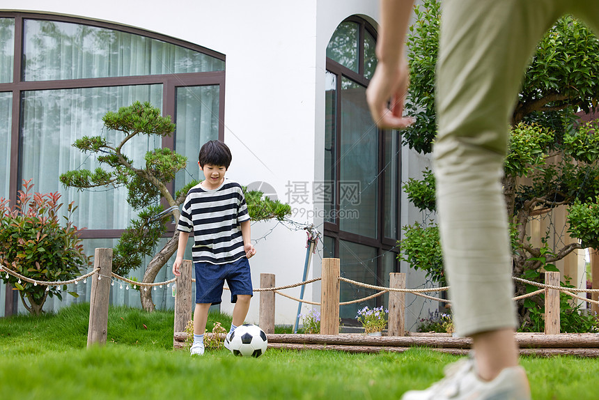 花园里踢足球的父子图片