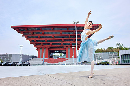 红色建筑物前舞蹈的女性图片
