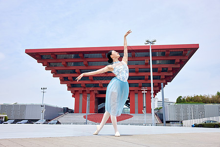 红色背景大气红色建筑前热爱舞蹈的女子背景