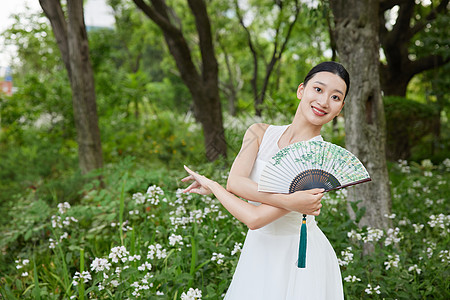 公园里舞扇的白裙女子图片