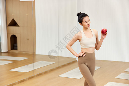 瑜伽年轻美女看着手中苹果图片