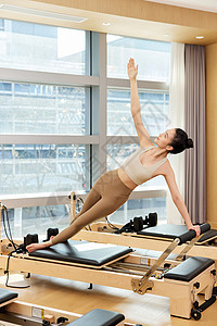 用普拉提核心床训练的运动女生图片