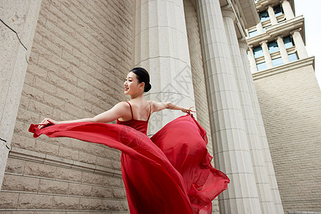 建筑下优美的红裙舞者图片