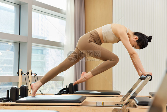 运动女生做普拉提核心床锻炼图片