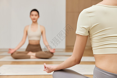 两个女生面对面练习瑜伽静坐背景图片