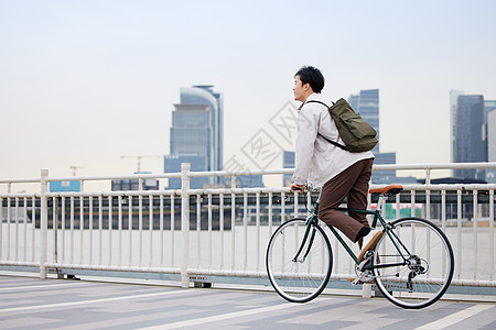 城市青年青年男性骑车去上班背景