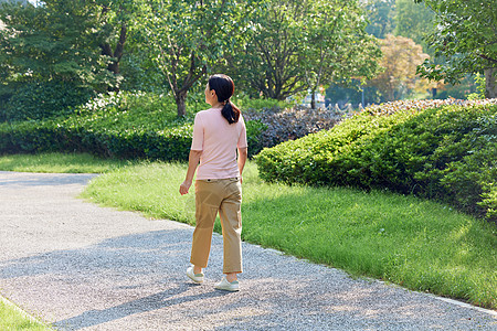 公园背景休闲女性小区散步背影背景