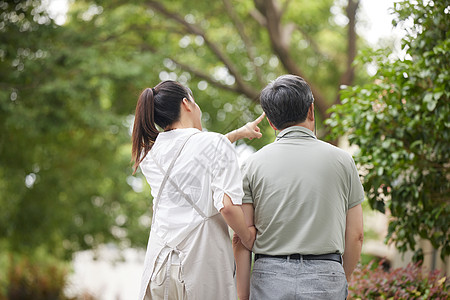 护工搀扶老人户外散步背影高清图片