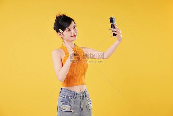 时尚女性对着手机打招呼图片