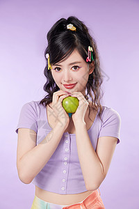 双手捧着苹果的年轻女性图片