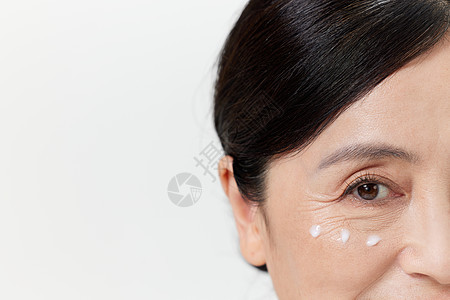 使用眼霜的中年女性图片