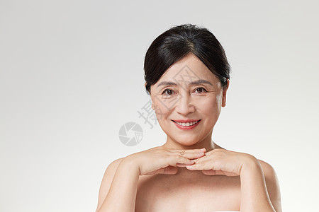 面部皮肤护理中年女性展示面部皮肤背景