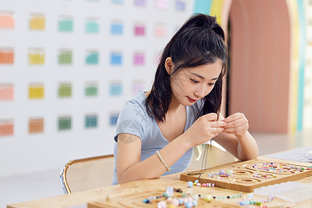 女生手工店专心制作手链背景图片