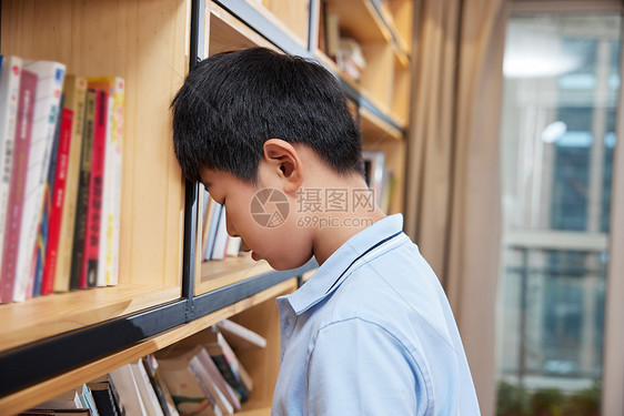 书架前厌学的男孩图片