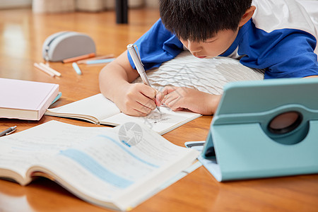 小学生书本学习趴在地上做作业的男孩背景