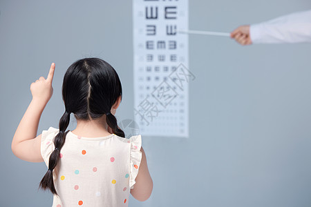 女生和花小女孩在医生指导下做视力测试背景