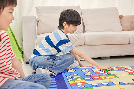 小男孩坐在客厅里玩飞行棋图片