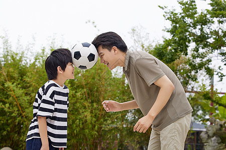 在院子里玩足球的父子图片