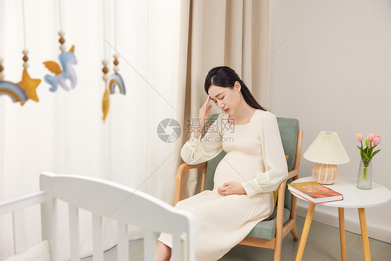 坐在沙发上头疼的孕妇图片