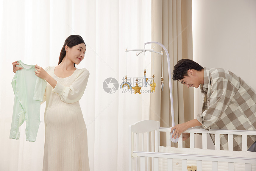准备婴儿房装饰的年轻夫妻图片