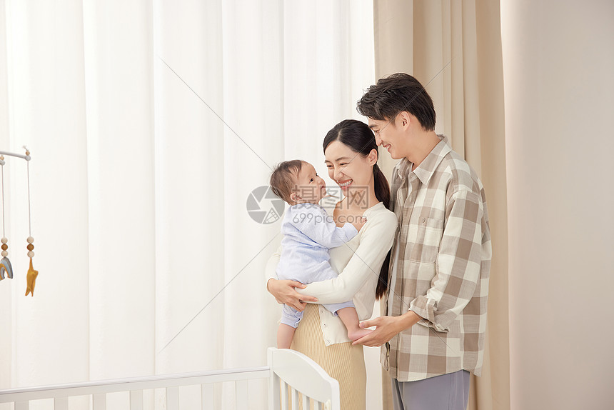 年轻夫妇抱着宝宝开心玩耍图片