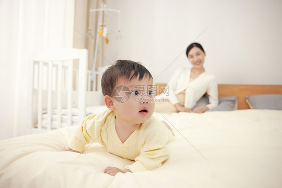 妈妈看着宝宝在床上爬来爬去图片