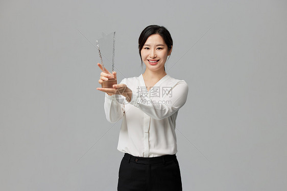 手拿奖杯的商务女性图片
