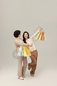 母女拎购物袋逛街背景图片