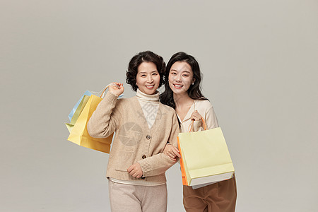 拎着购物袋的母亲和女儿图片