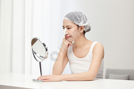 戴着鼻夹在镜子面前做搞怪表情的可爱女生图片