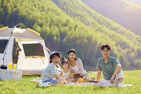 户外登山素材幸福的一家人坐在草地上背景