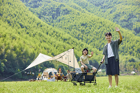 夏天背景儿子坐在爸爸的手拉车里玩耍背景