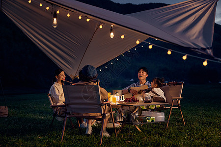户外露营夜晚幸福的一家人在聊天图片