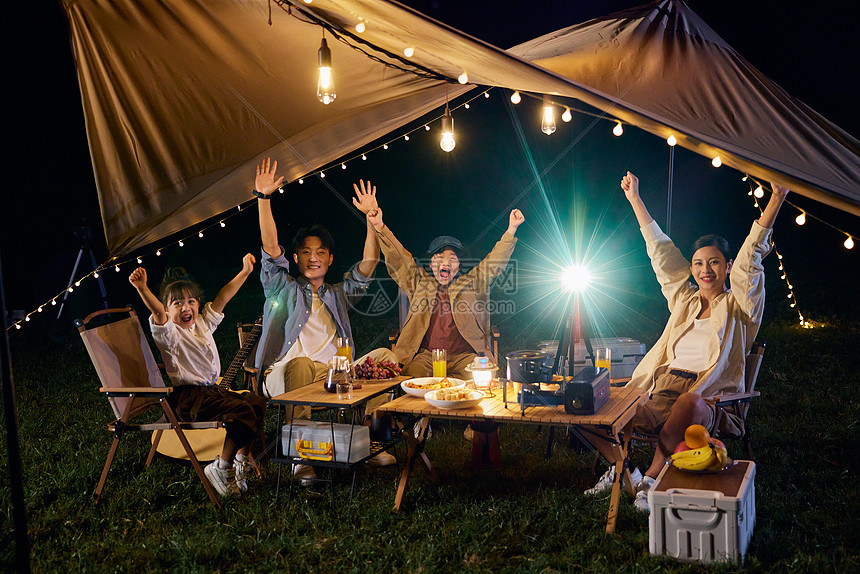 户外露营一家人举起手来快乐的拍照图片