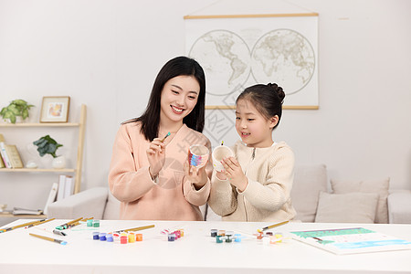 花水彩正拿着水彩颜料认真画画的母女俩背景