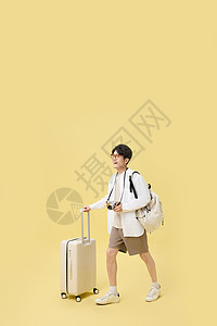 背着书包推着行李箱旅游的年轻大学生图片