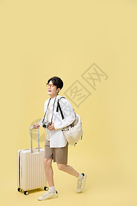 背着书包推着行李箱旅游的年轻大学生图片