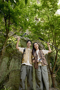 一对情侣在山上举着登山杖摆拍图片