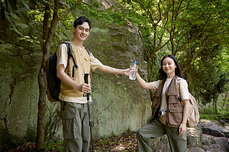 男孩给女朋友在登山途中递水图片