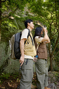 一对情侣拿着相机在拍山上景色图片