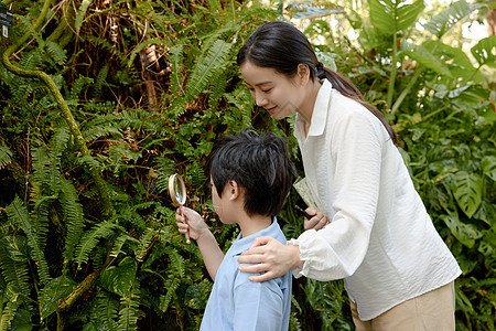 带着儿子参观植物园的年轻女人图片