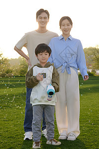 户外玩泡泡机的一家人图片