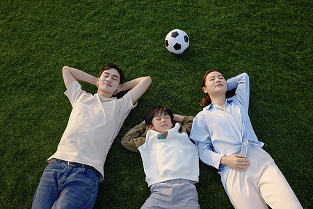 运动后躺在草坪上放松的一家三口图片