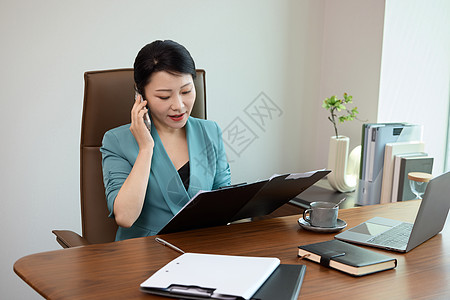 女白领坐在电脑前打电话图片