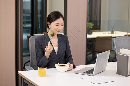 办公室里正在吃轻食的女职员图片