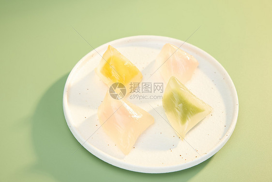 绿色背景下盘中彩色水晶粽子图片