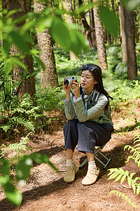 森林里坐在小板凳上拍照的女孩图片